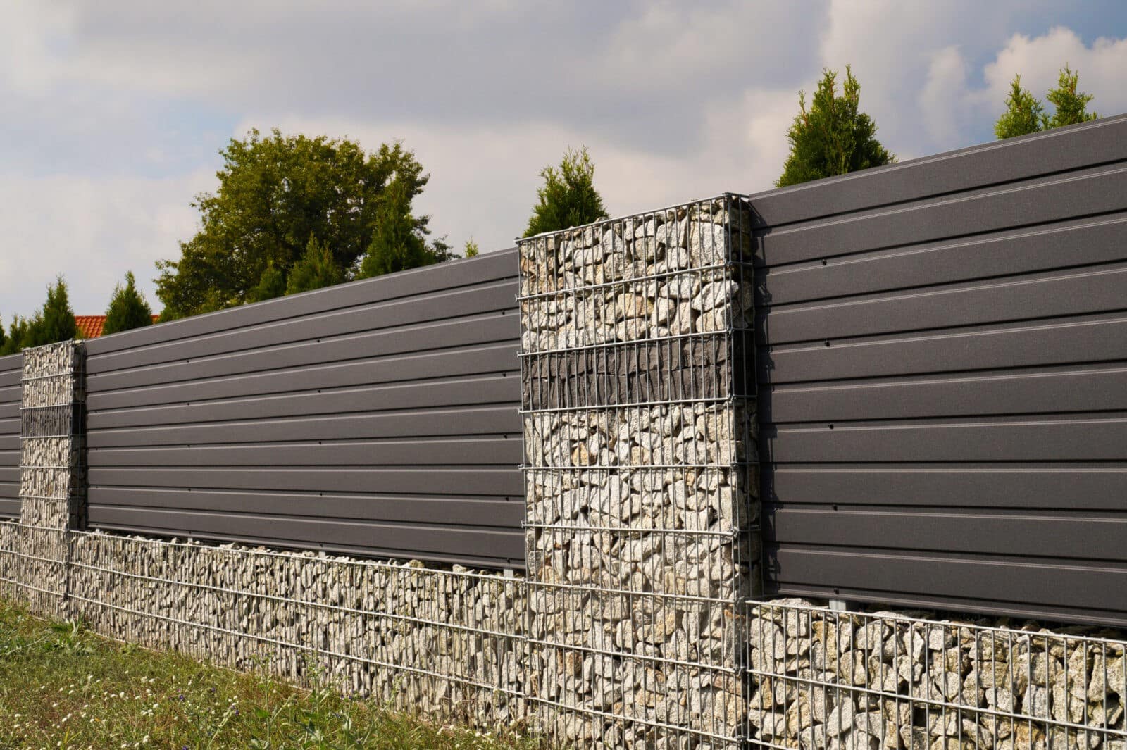 Sichtschutzwand mit Gabionen als Steinsäulen und durchgehendem Sockel