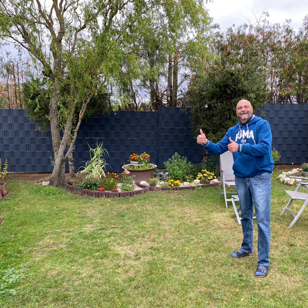 Dunkelblauer Sichtschutzzaun im Garten, Mann zeigt Daumen hoch – Projektfoto 7